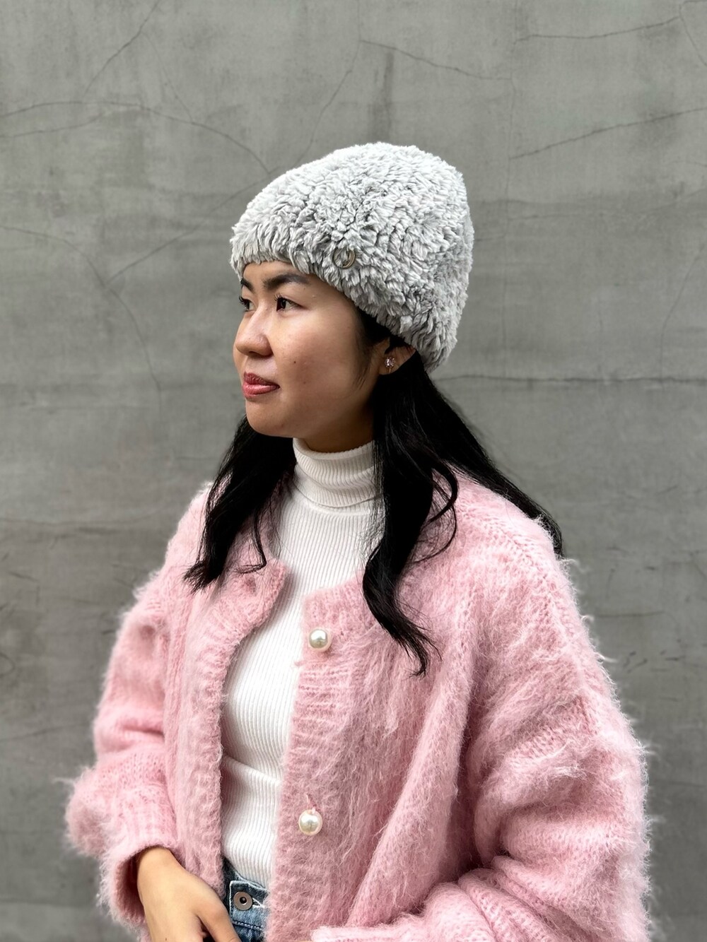 ピンク系のカーディガン/ボレロ、ブルー系のデニムパンツ、ピンク系のブーツを着用したレディースの冬コーディネートの6枚目の写真