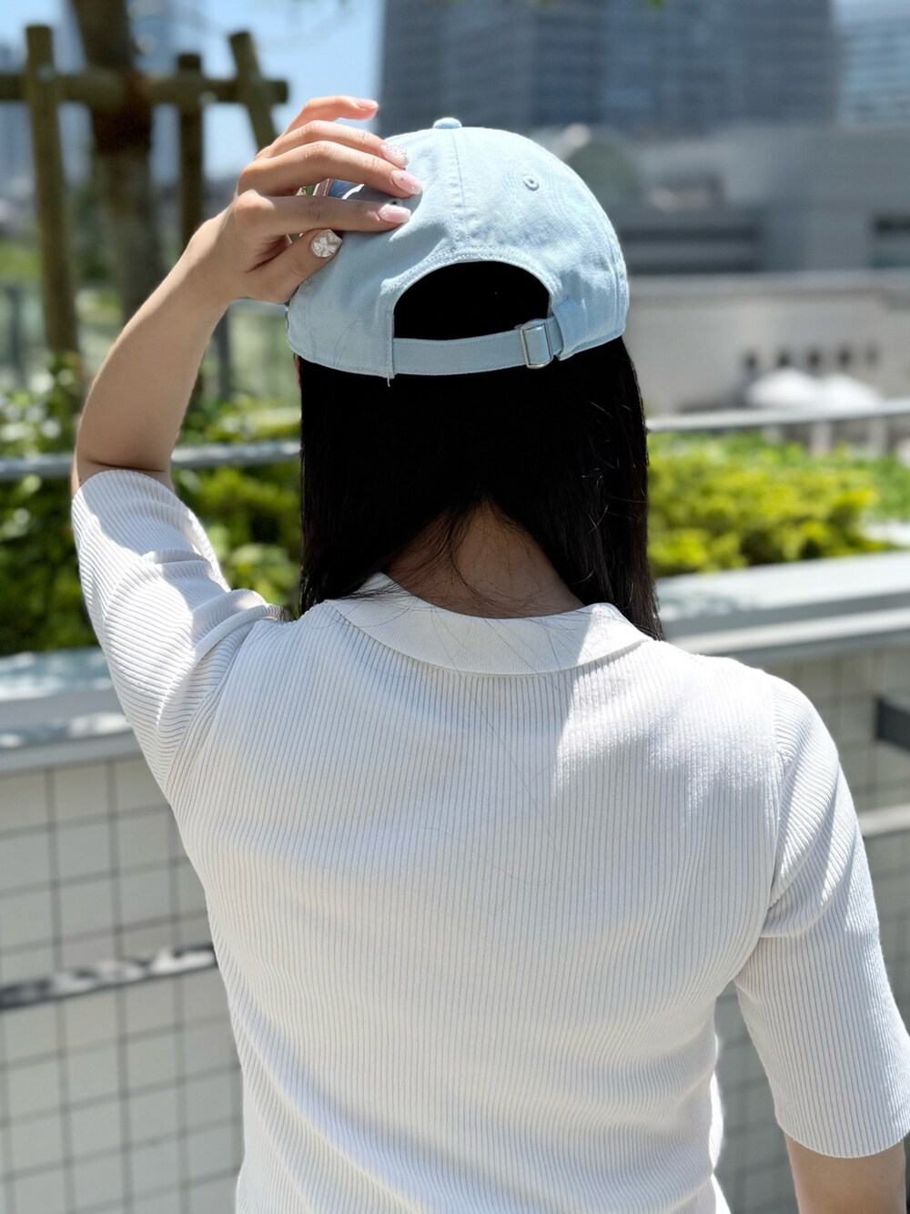 ホワイト系のニット/セーター、グレー系のスラックス、グレー系のスニーカーを着用したレディースの夏コーディネートの6枚目の写真