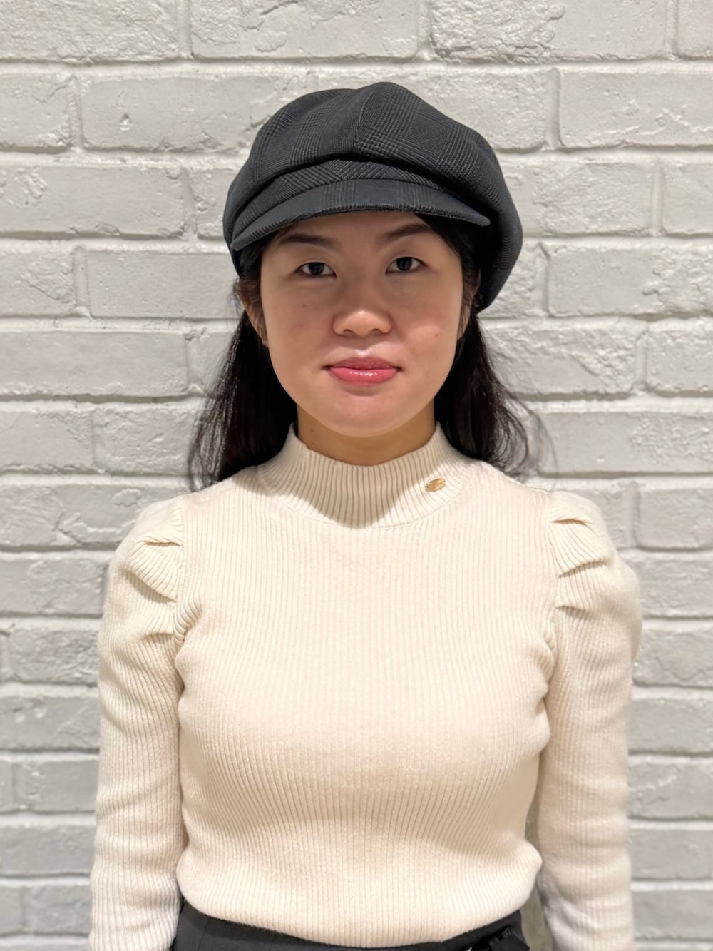 ベージュ系のニット/セーター、グレー系のスカート、ブラック系のブーツを着用したレディースの冬コーディネートの5枚目の写真