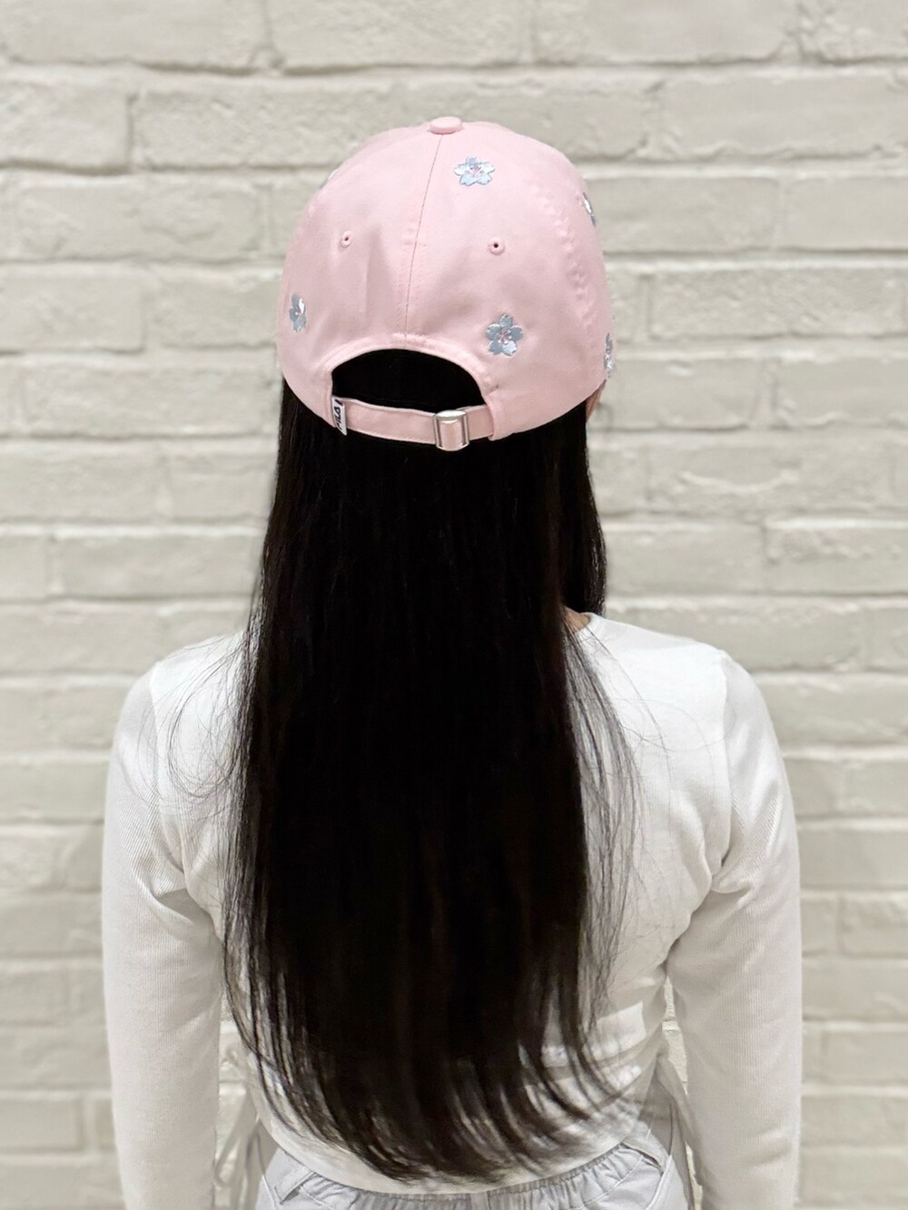 ホワイト系のTシャツ/カットソー、グレー系のデニムパンツ、ホワイト系のスニーカーを着用したレディースの春コーディネートの5枚目の写真