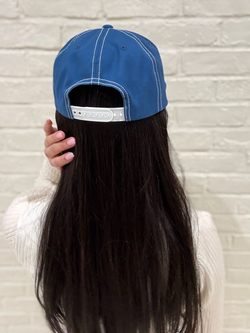 ホワイト系のニット/セーター、ホワイト系のデニムパンツ、ブラック系のブーツを着用したレディースの夏コーディネートの3枚目の写真