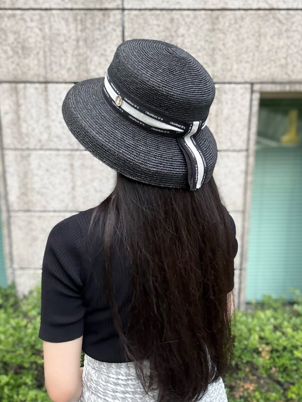グレー系のスカート、シルバー系のスニーカー、ブラック系のニット/セーターを着用したレディースの夏コーディネートの4枚目の写真