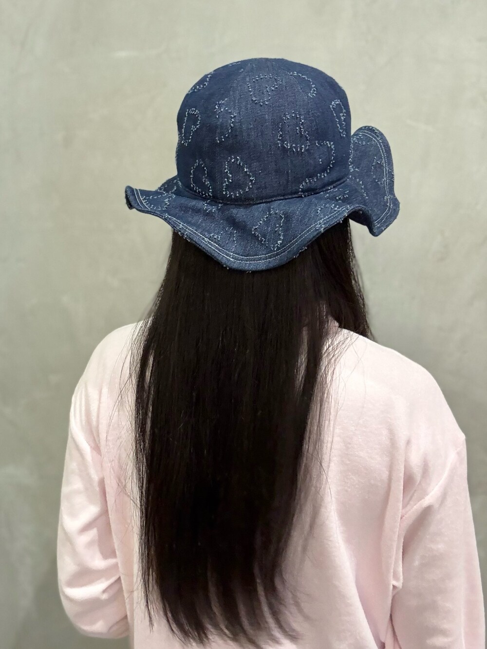 ピンク系のスウェット、ブルー系のデニムパンツ、グレー系のスニーカーを着用したレディースの春コーディネートの3枚目の写真