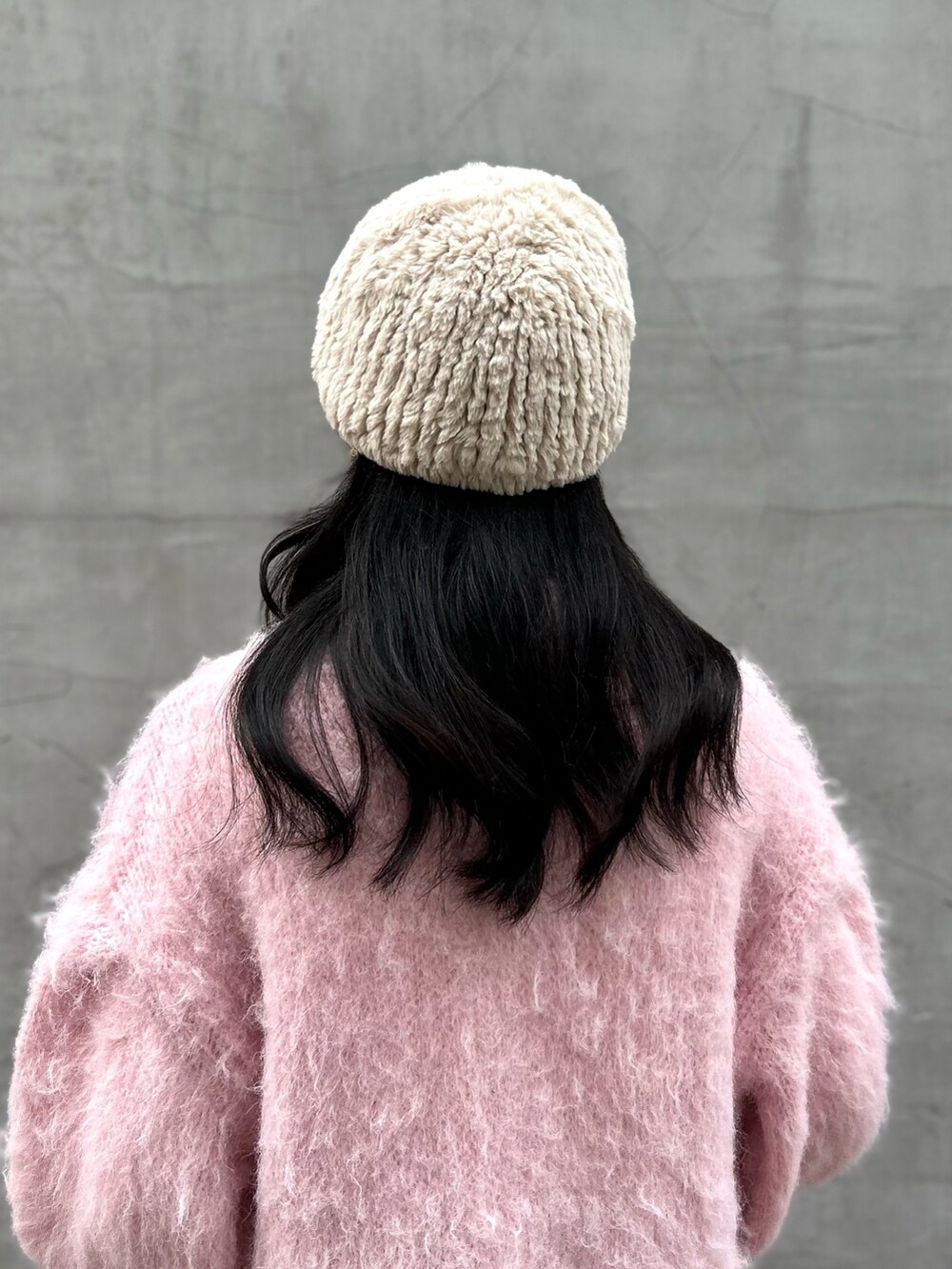 ピンク系のカーディガン/ボレロ、ブルー系のデニムパンツ、ピンク系のブーツを着用したレディースの冬コーディネートの4枚目の写真