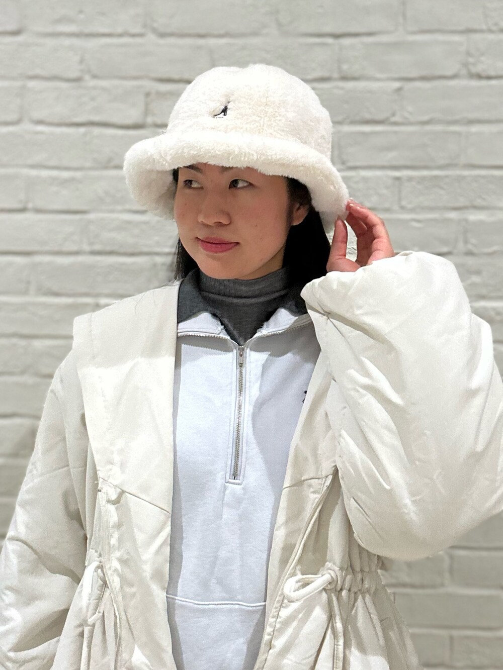 ホワイト系のダウンジャケット/コート、グレー系のニット/セーター、ブルー系のスウェットを着用したレディースの冬コーディネートの2枚目の写真