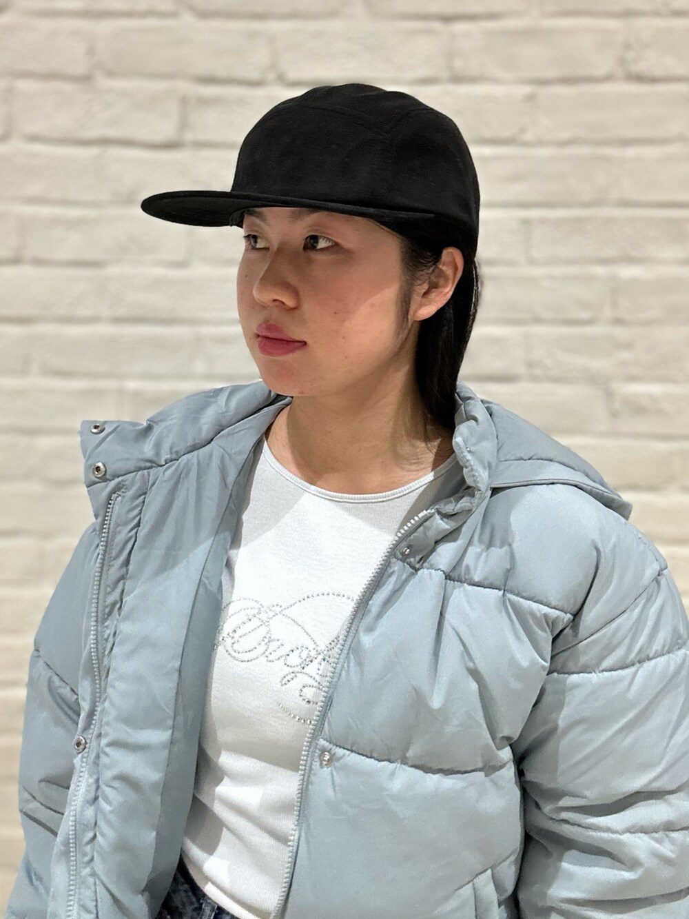 ブルー系のダウンジャケット/コート、ブルー系のTシャツ/カットソー、ブルー系のデニムパンツを着用したレディースの冬コーディネートの6枚目の写真