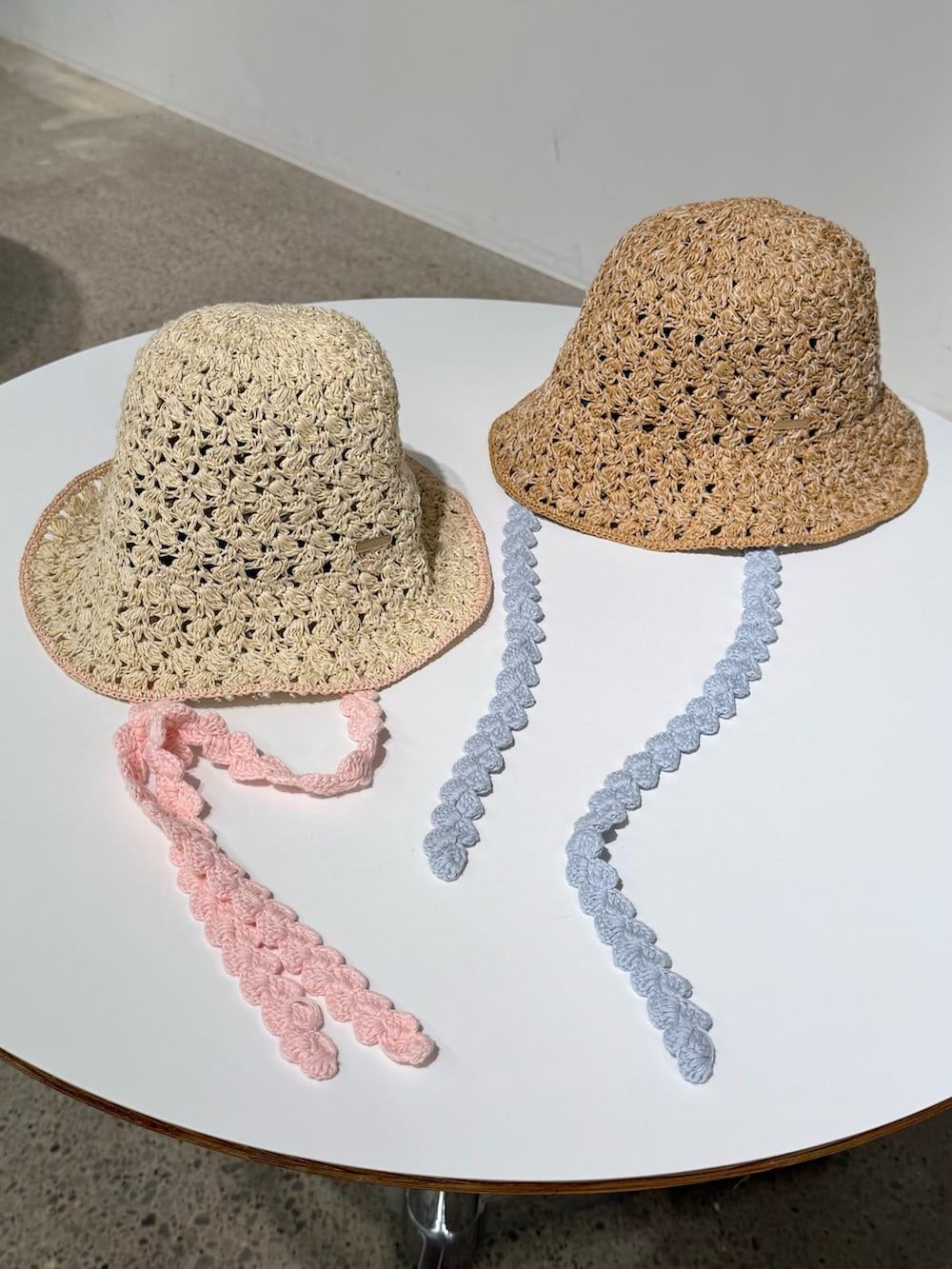 ホワイト系のニット/セーター、ピンク系のスカート、ホワイト系のシューズを着用したレディースの夏コーディネートの6枚目の写真