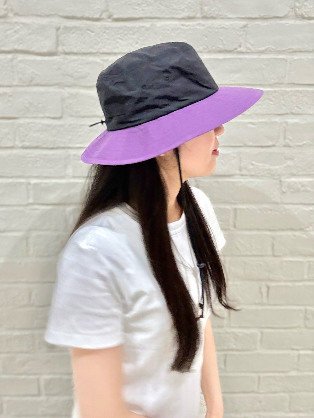 ホワイト系のTシャツ/カットソー、グレー系のその他パンツ、ブラック系のハットを着用したレディースの夏コーディネートの3枚目の写真