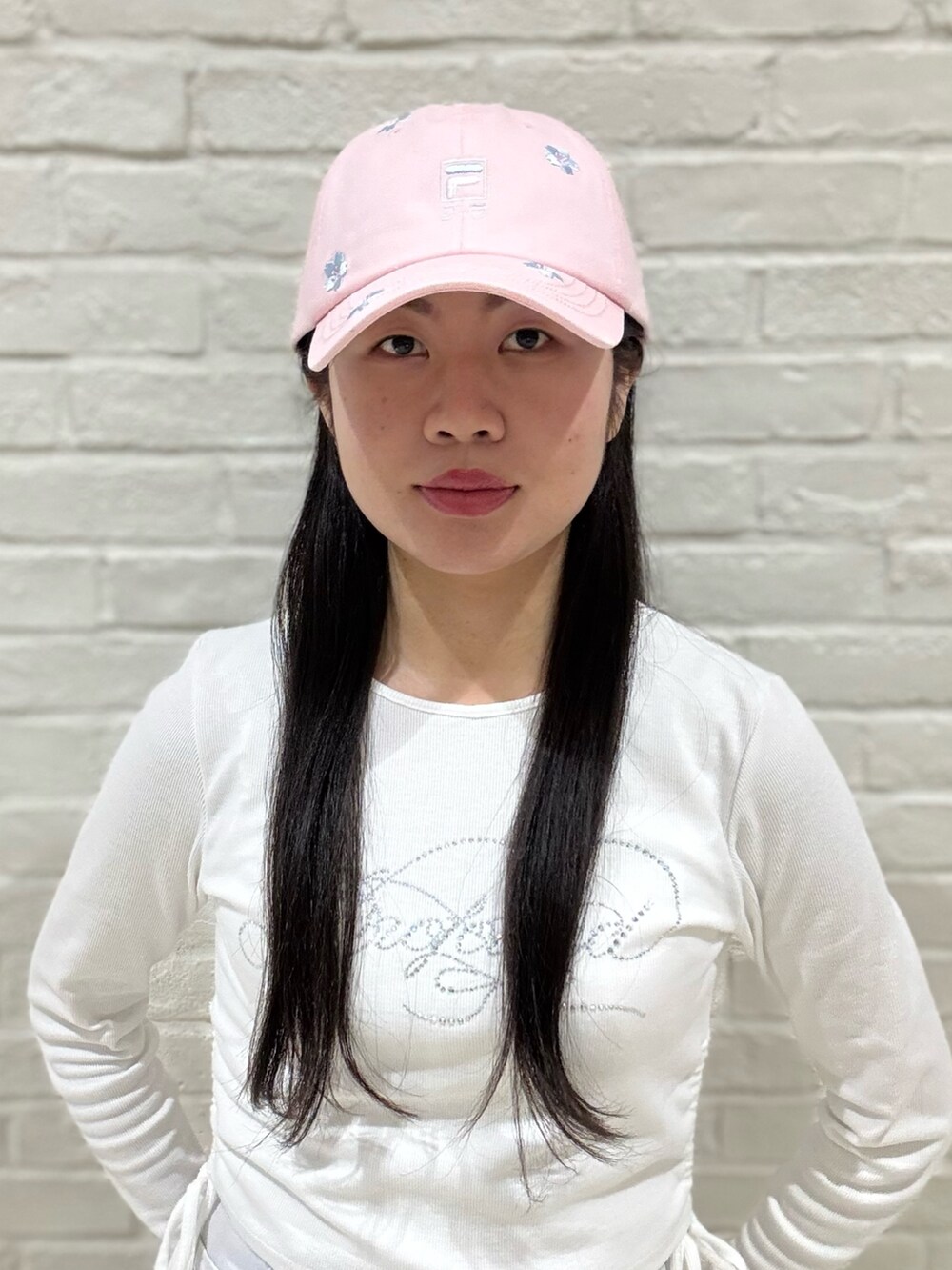 ホワイト系のTシャツ/カットソー、グレー系のデニムパンツ、ホワイト系のスニーカーを着用したレディースの春コーディネートの2枚目の写真