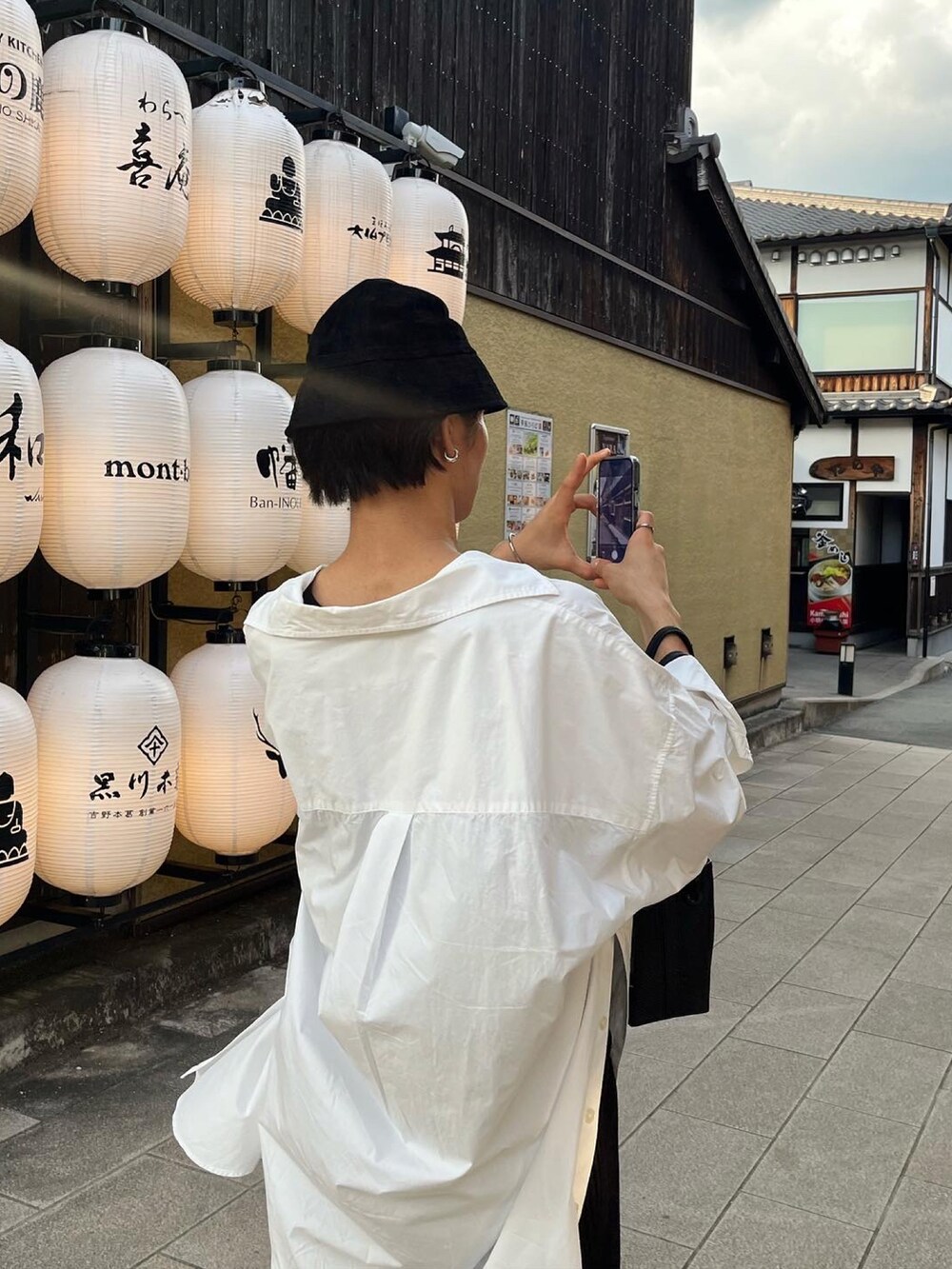 ホワイト系のシャツ/ブラウス、ホワイト系のスニーカー、ブラック系のハットを着用したメンズの夏コーディネートの3枚目の写真