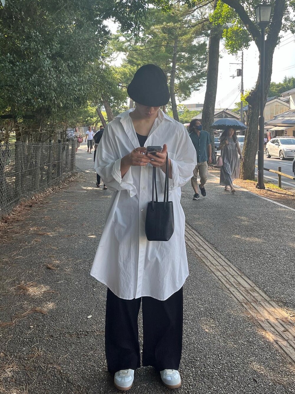 ホワイト系のシャツ/ブラウス、ホワイト系のスニーカー、ブラック系のハットを着用したメンズの夏コーディネートの4枚目の写真