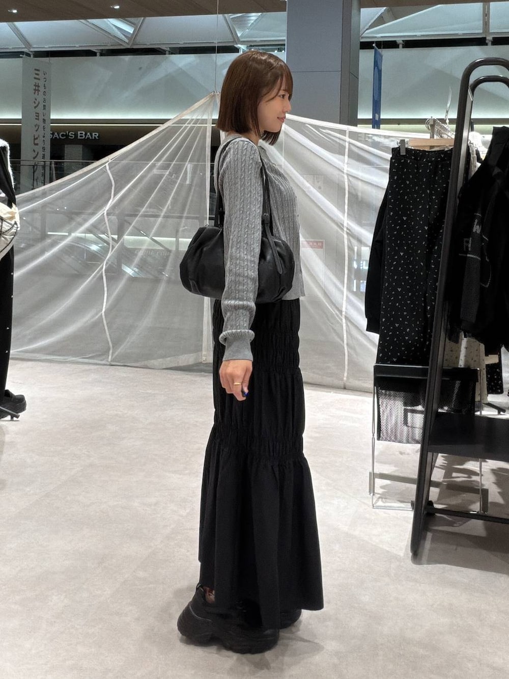 グレー系のカーディガン/ボレロ、ブラック系のボストンバッグ、ブラック系のスカートを着用したレディースの秋コーディネートの2枚目の写真