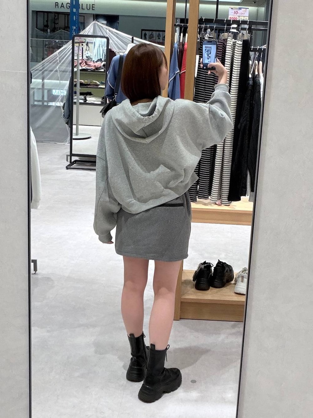 グレー系のスカート、グレー系のパーカーを着用したレディースの秋コーディネートの2枚目の写真
