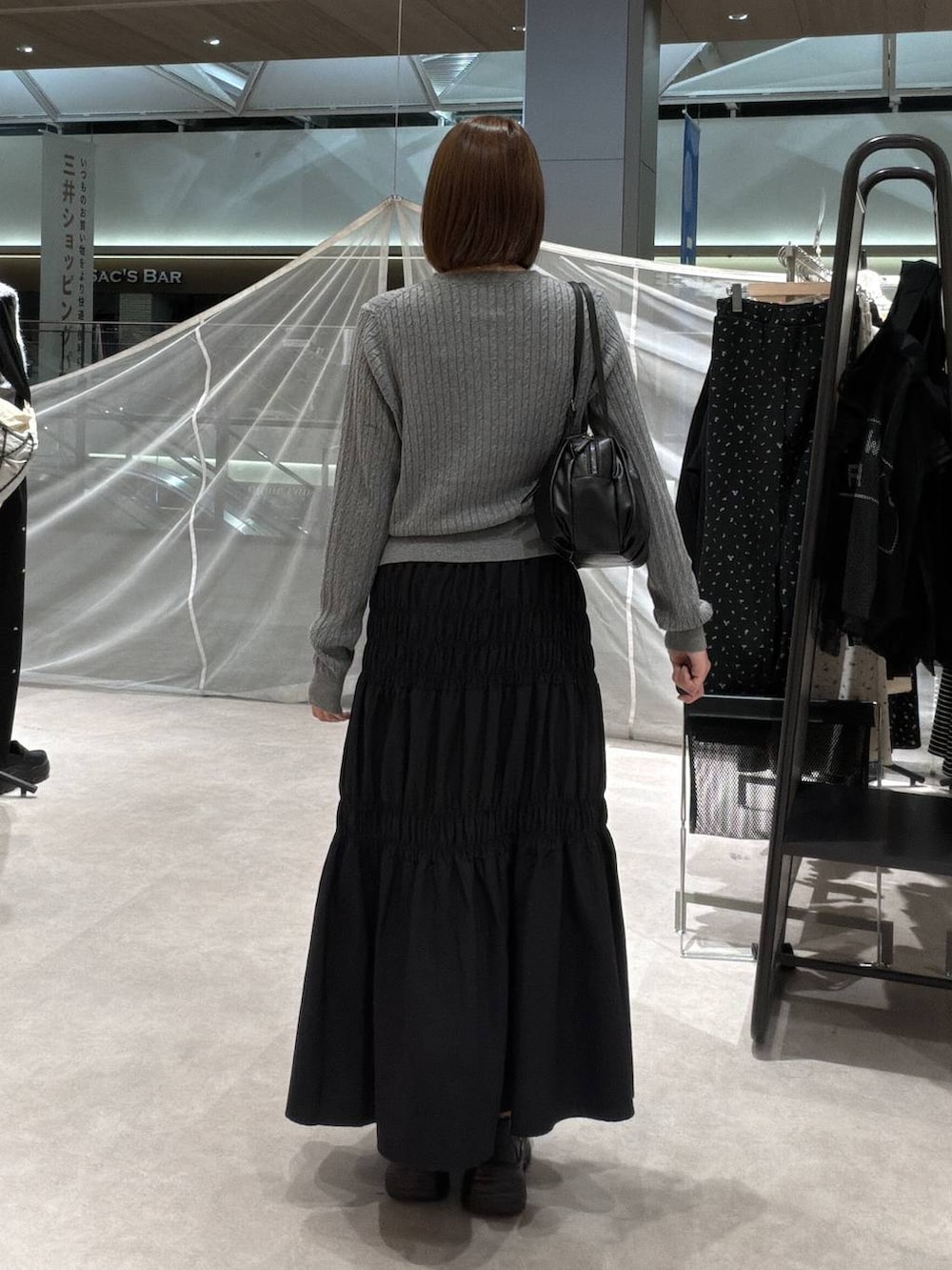 グレー系のカーディガン/ボレロ、ブラック系のボストンバッグ、ブラック系のスカートを着用したレディースの秋コーディネートの3枚目の写真