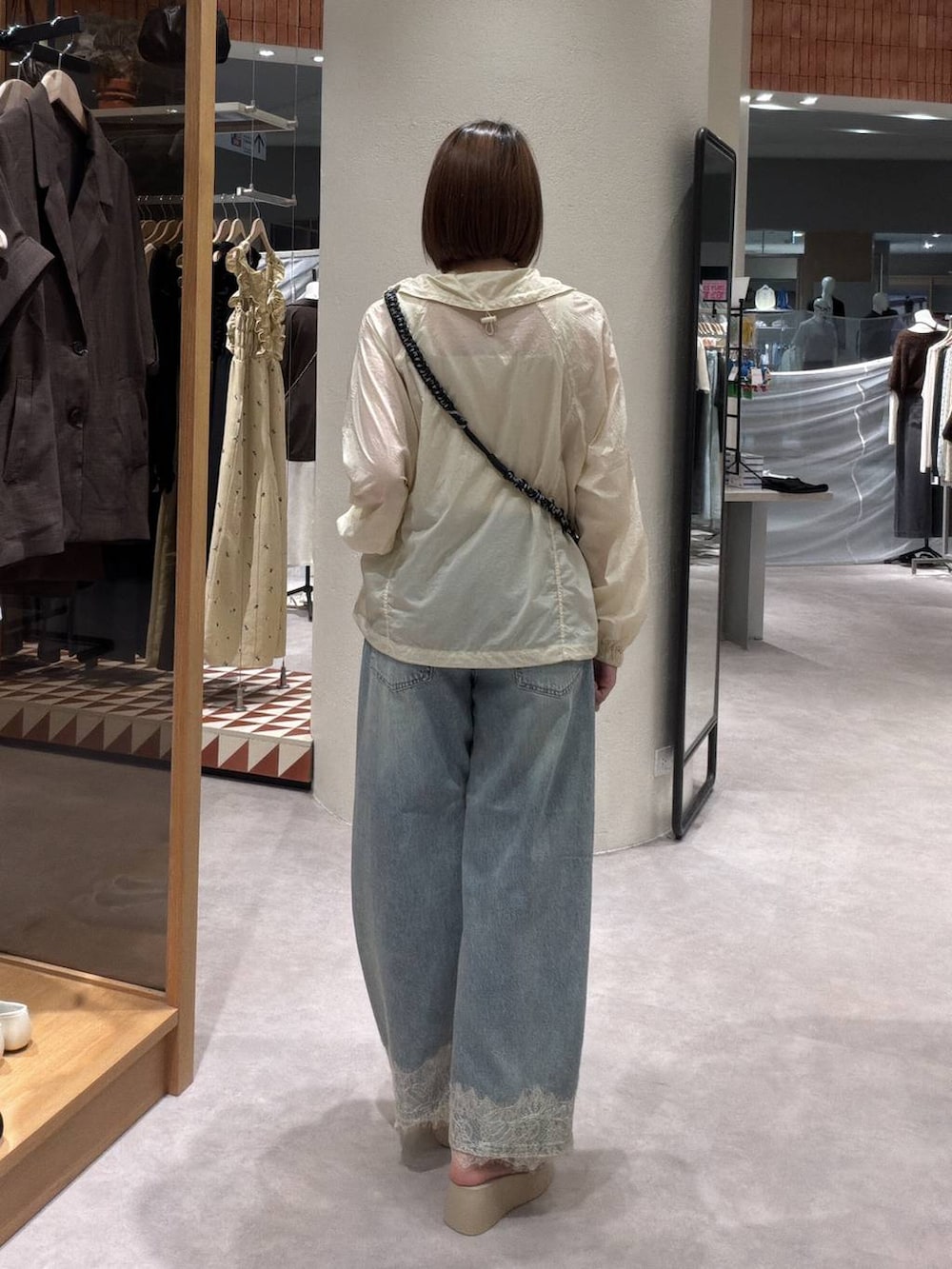 イエロー系のカーディガン/ボレロ、ゴールド系のタンクトップ、ブルー系のデニムパンツを着用したレディースの夏コーディネートの3枚目の写真