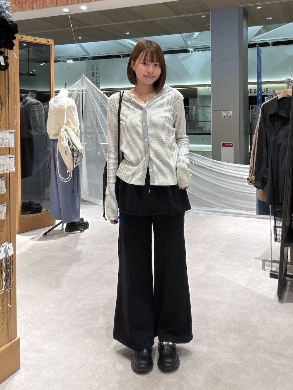 ブラック系のスウェットパンツ、グレー系のカーディガン/ボレロ、シルバー系のタンクトップを着用したレディースの秋コーディネートの4枚目の写真