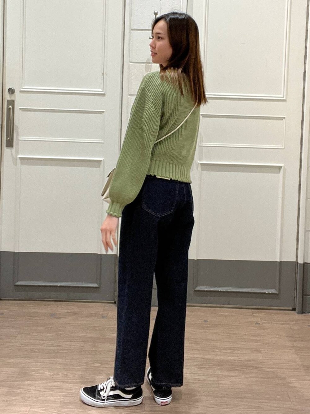 ホワイト系のショルダーバッグ、ホワイト系のTシャツ/カットソー、ブルー系のデニムパンツを着用したレディースの春コーディネートの2枚目の写真