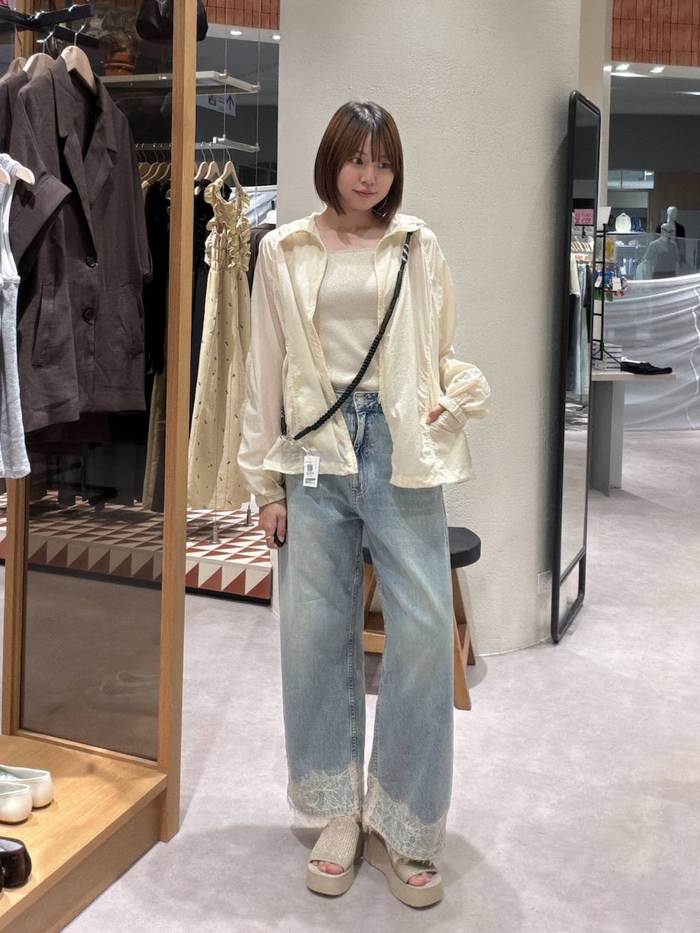 イエロー系のカーディガン/ボレロ、ゴールド系のタンクトップ、ブルー系のデニムパンツを着用したレディースの夏コーディネートの4枚目の写真