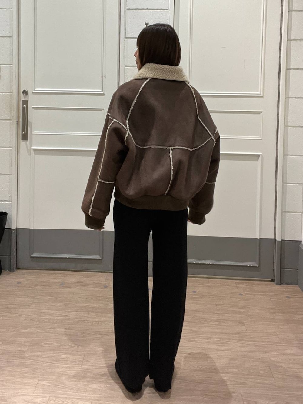 ブラウン系のブルゾン、ブラック系のその他パンツ、ブラック系のバレエシューズを着用したレディースの冬コーディネートの3枚目の写真