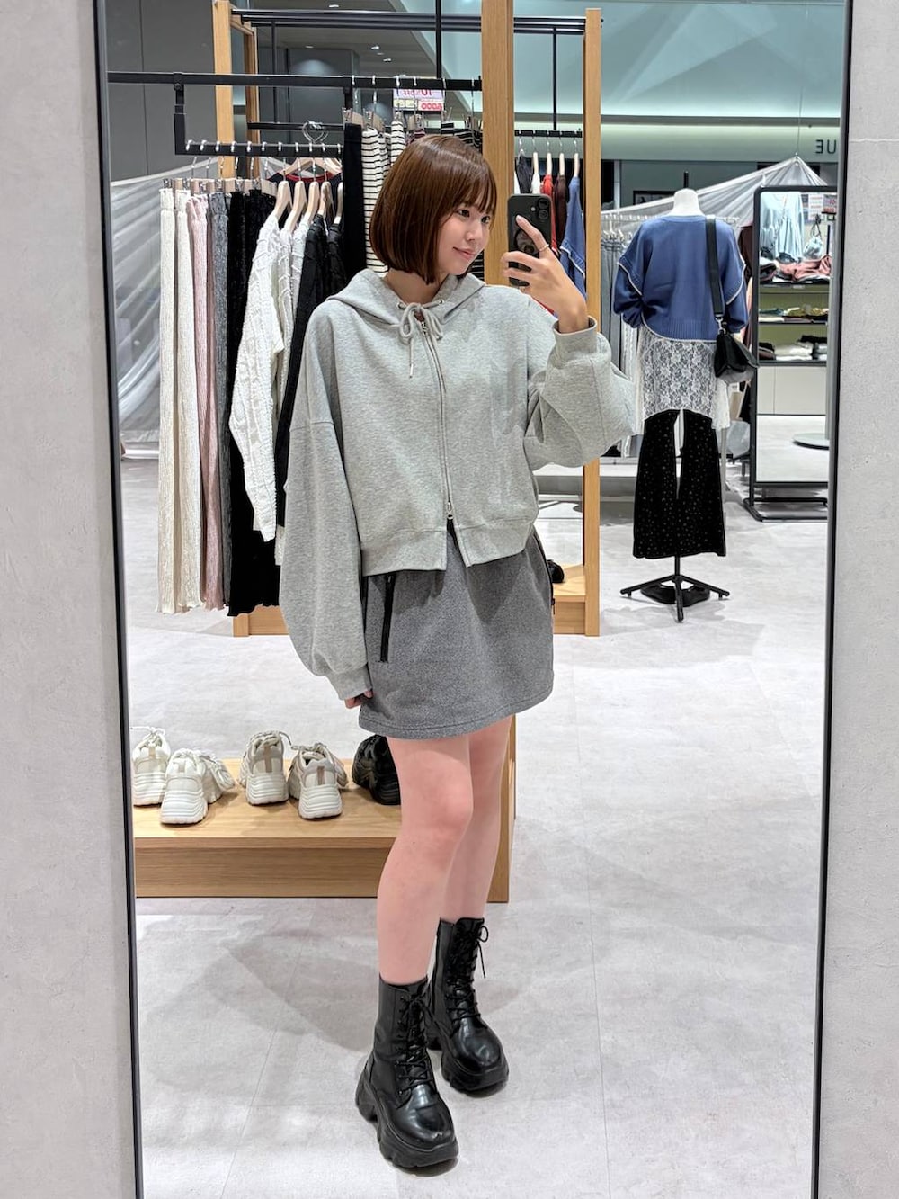 グレー系のスカート、グレー系のパーカーを着用したレディースの秋コーディネートの4枚目の写真
