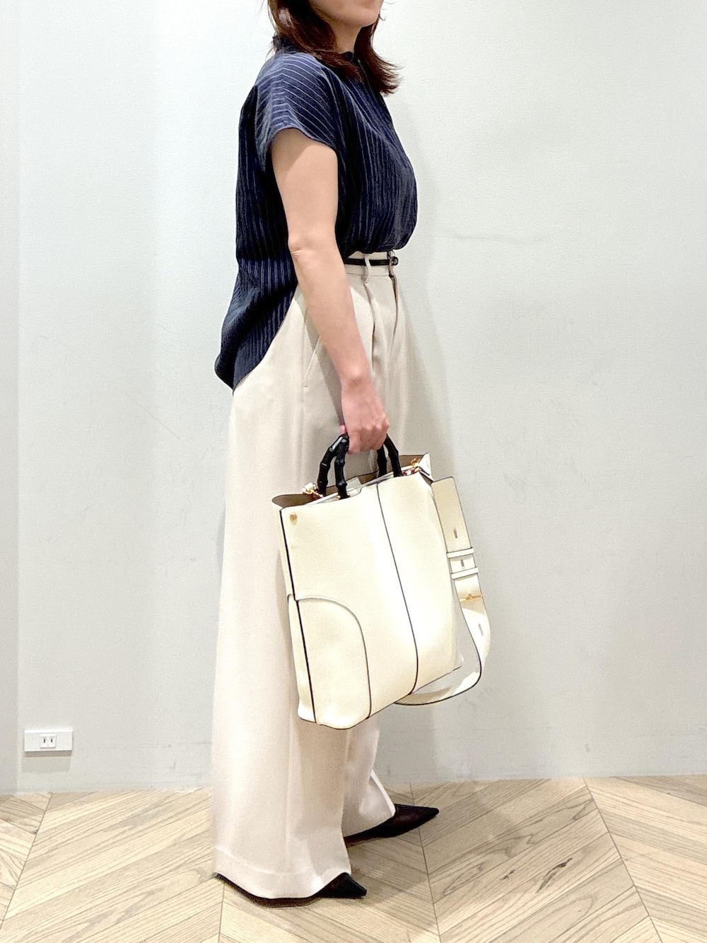 ホワイト系のトートバッグ、ブラック系のパンプス、ベージュ系のその他パンツを着用したレディースの夏コーディネートの4枚目の写真