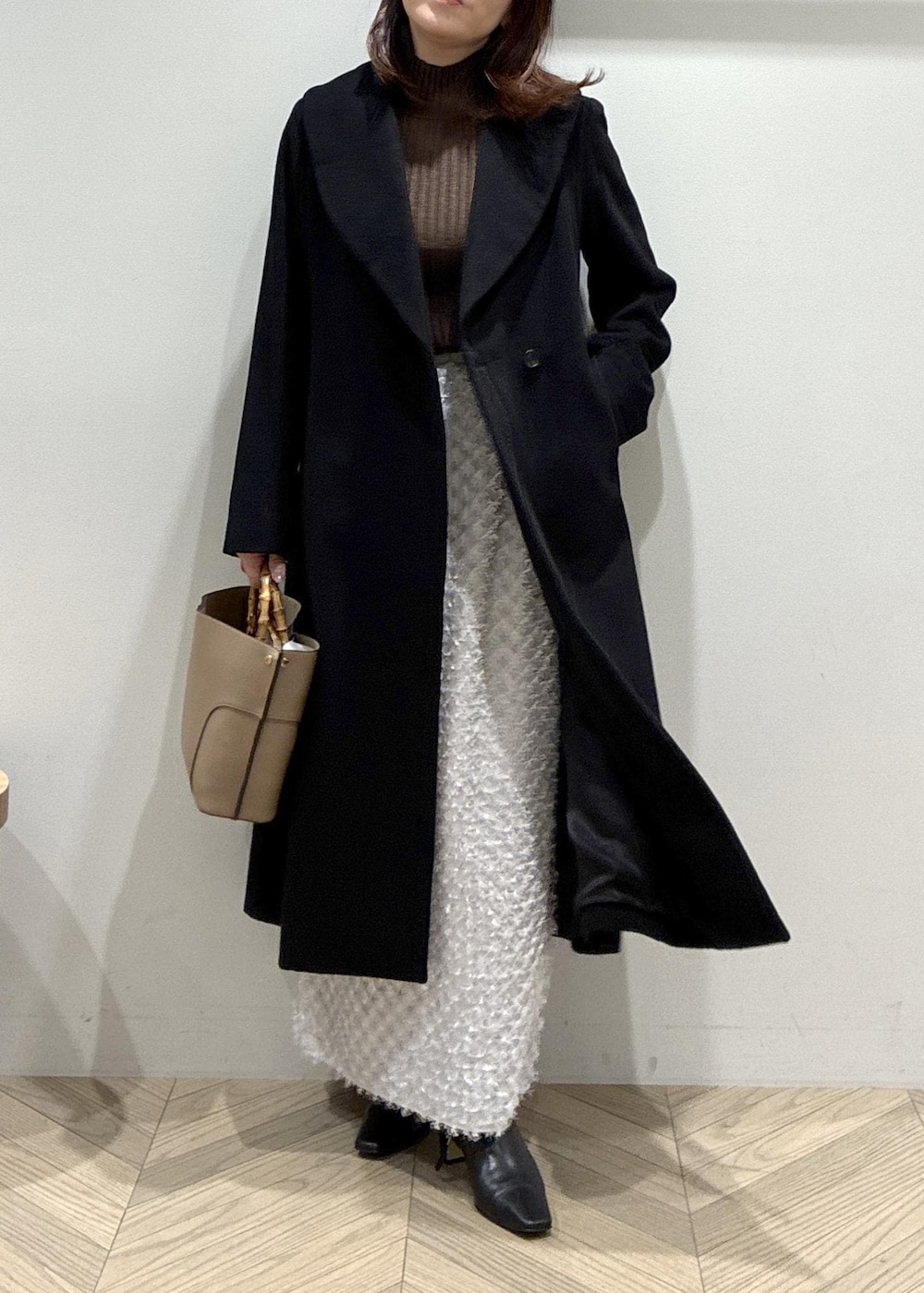 ブラック系のブーツ、シルバー系のスカート、ブラウン系のニット/セーターを着用したレディースの冬コーディネートの4枚目の写真