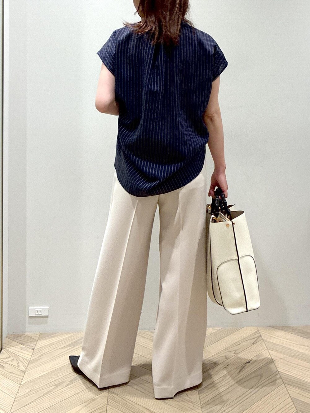 ホワイト系のトートバッグ、ブラック系のパンプス、ベージュ系のその他パンツを着用したレディースの夏コーディネートの6枚目の写真