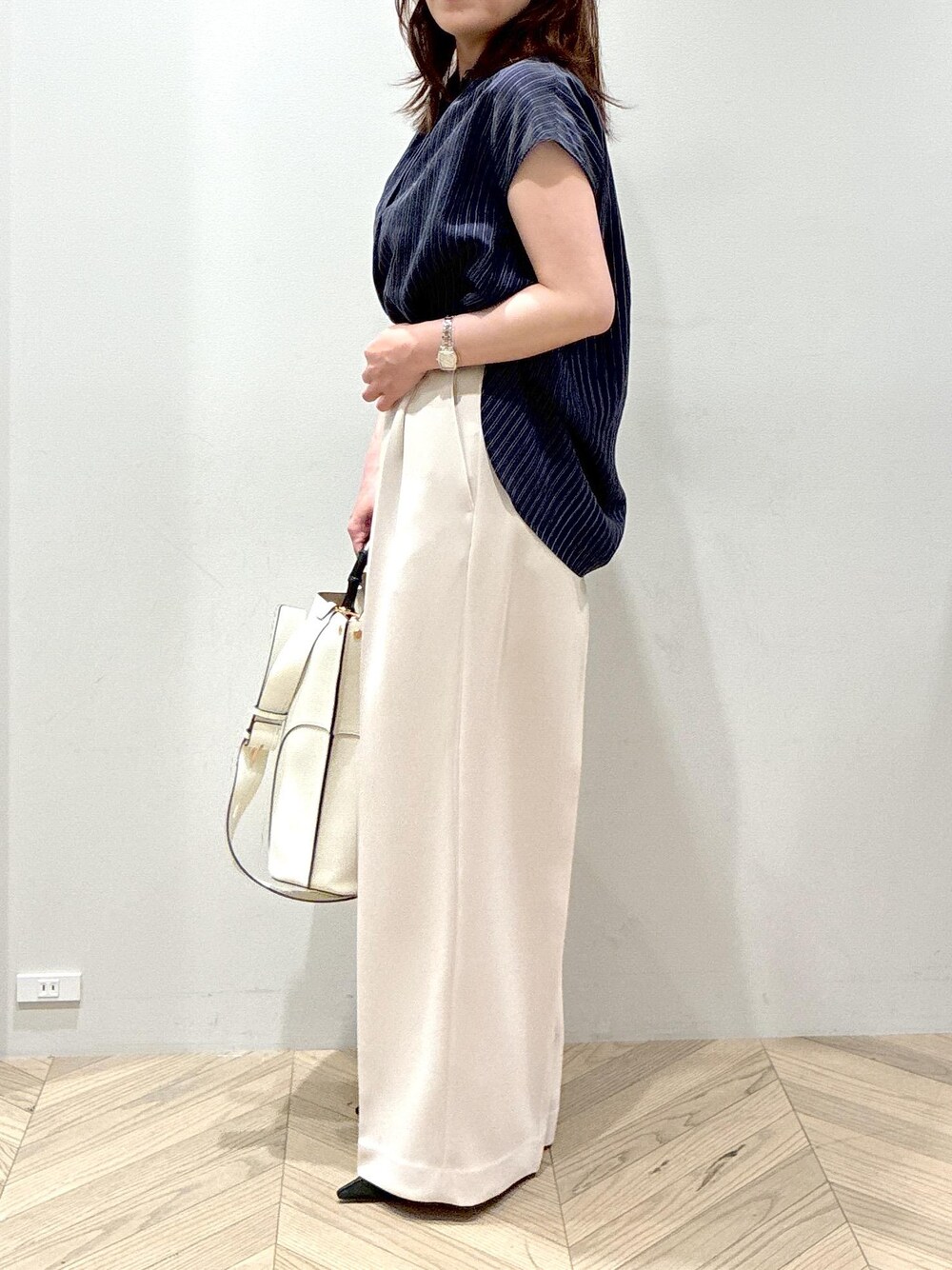 ホワイト系のトートバッグ、ブラック系のパンプス、ベージュ系のその他パンツを着用したレディースの夏コーディネートの5枚目の写真