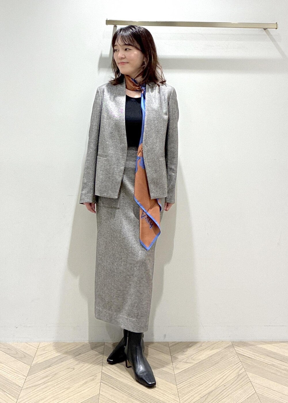 ブラック系のブーツ、ブラック系のスカート、ブラック系のニット/セーターを着用したレディースの秋コーディネートの2枚目の写真