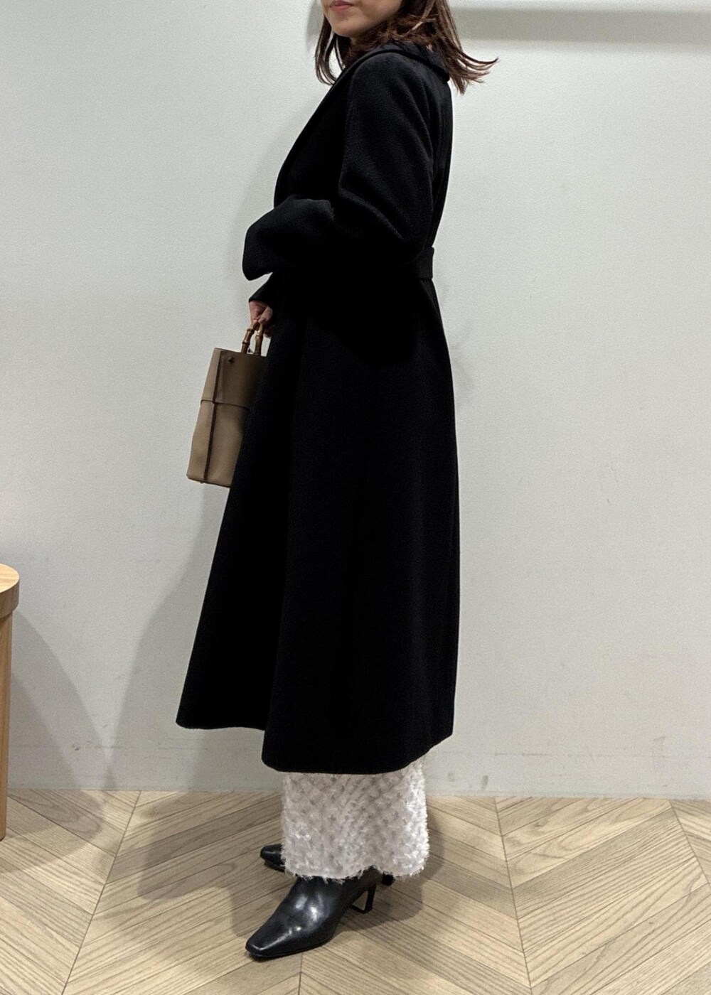 ブラック系のブーツ、シルバー系のスカート、ブラウン系のニット/セーターを着用したレディースの冬コーディネートの5枚目の写真