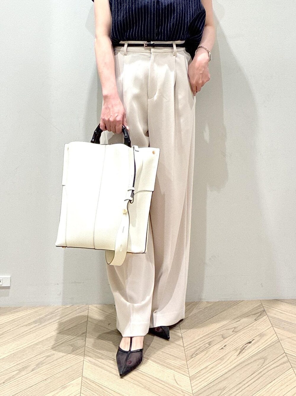ホワイト系のトートバッグ、ブラック系のパンプス、ベージュ系のその他パンツを着用したレディースの夏コーディネートの8枚目の写真