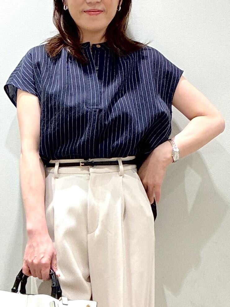 ホワイト系のトートバッグ、ブラック系のパンプス、ベージュ系のその他パンツを着用したレディースの夏コーディネートの7枚目の写真