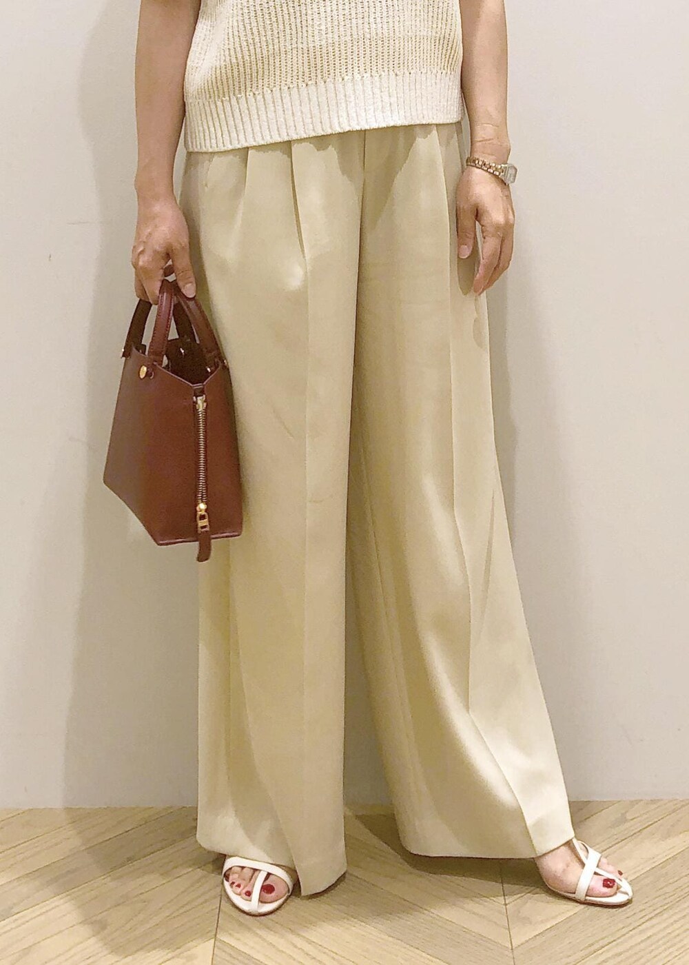 ホワイト系のサンダル、レッド系のハンドバッグ、ホワイト系のベストを着用したレディースの夏コーディネートの7枚目の写真