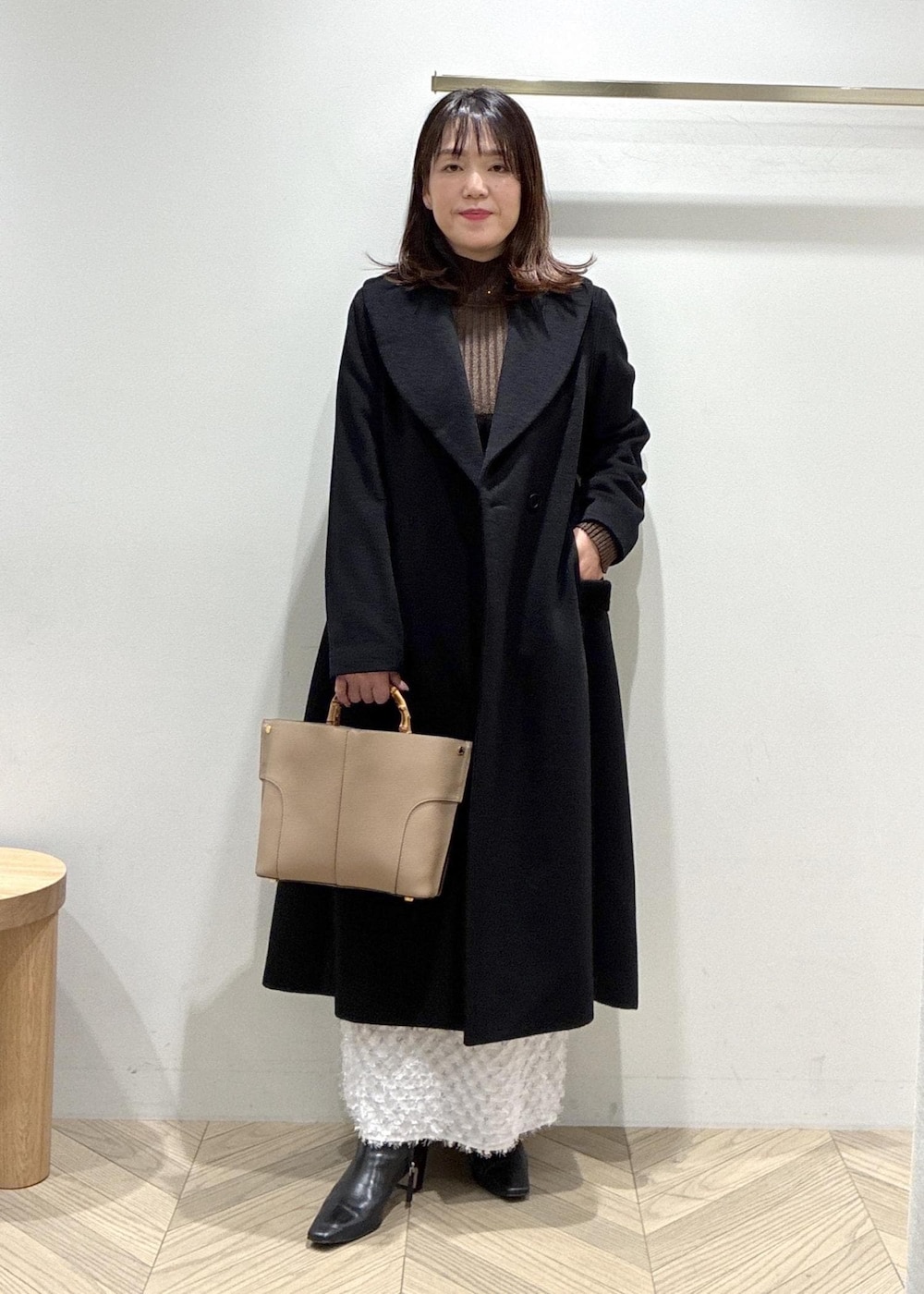 ブラック系のブーツ、シルバー系のスカート、ブラウン系のニット/セーターを着用したレディースの冬コーディネートの3枚目の写真