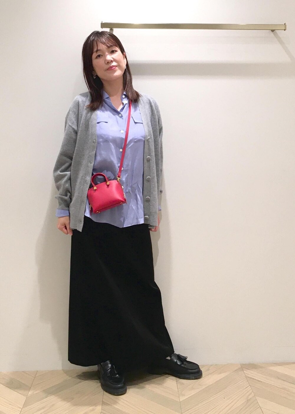 ブラック系のスカート、ブルー系のシャツ/ブラウス、グレー系のカーディガン/ボレロを着用したレディースの秋コーディネートの2枚目の写真