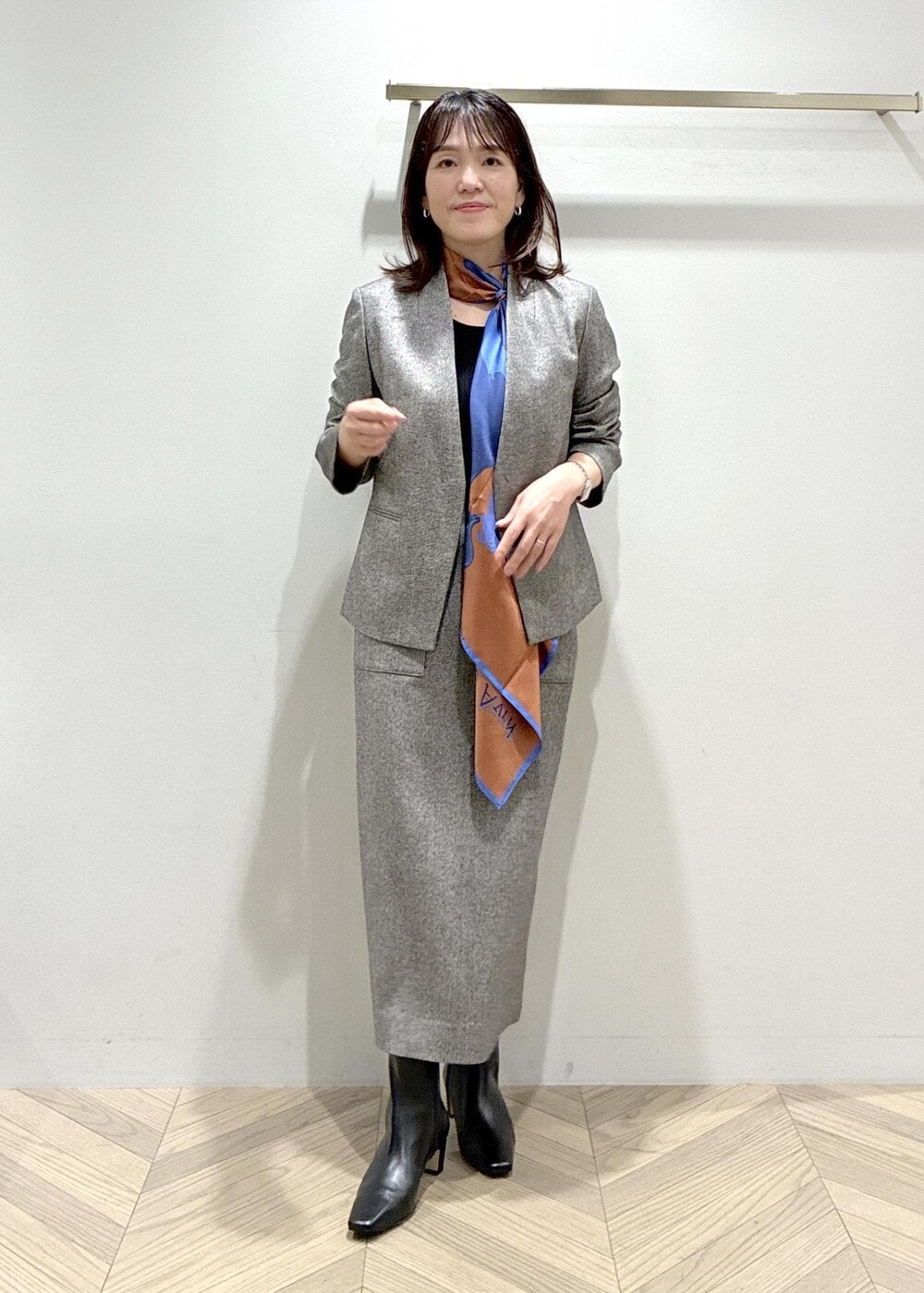 ブラック系のブーツ、ブラック系のスカート、ブラック系のニット/セーターを着用したレディースの秋コーディネートの3枚目の写真