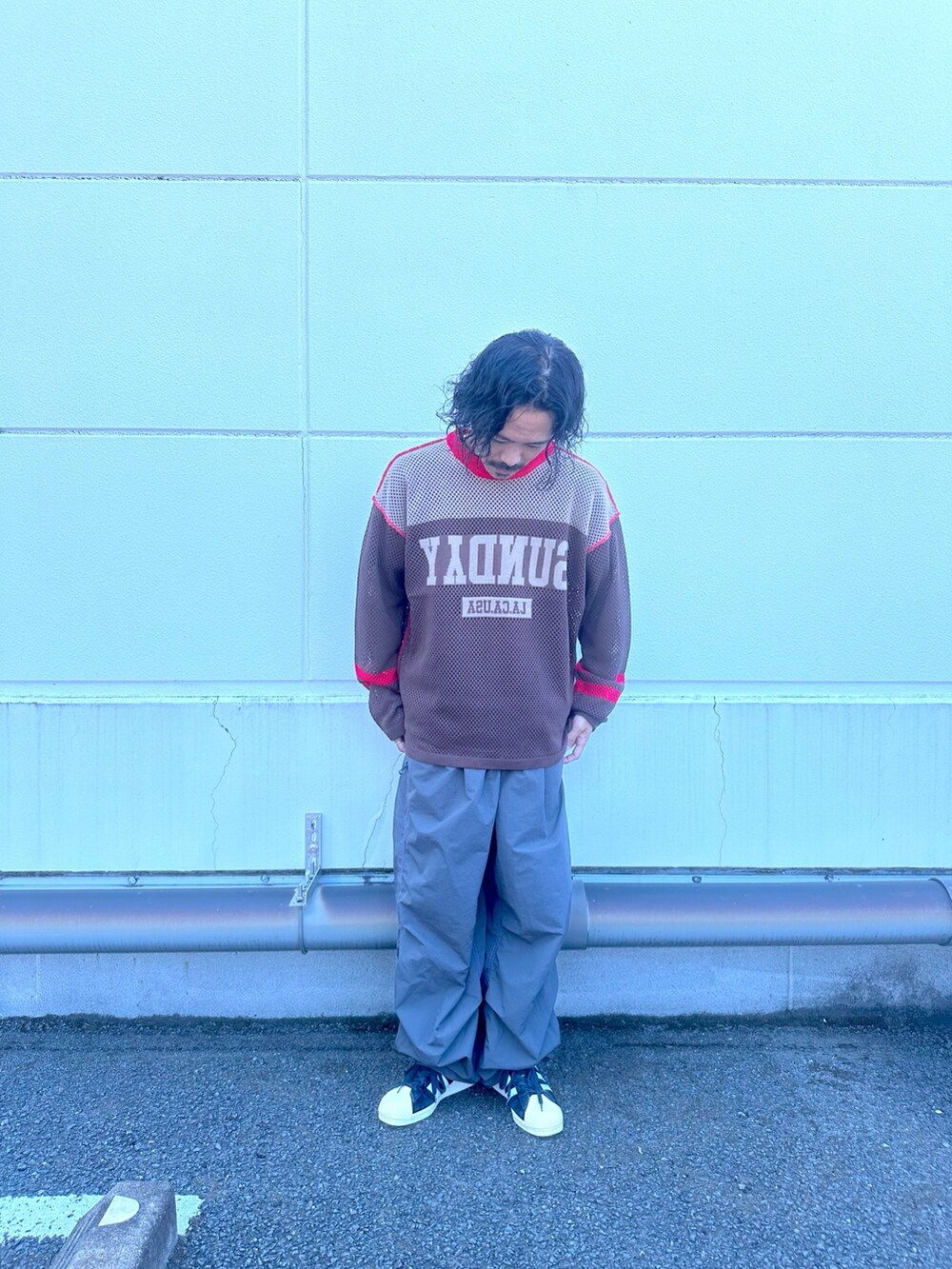 ブラウン系のニット/セーター、ブラック系のカーゴパンツを着用したメンズの夏コーディネートの2枚目の写真