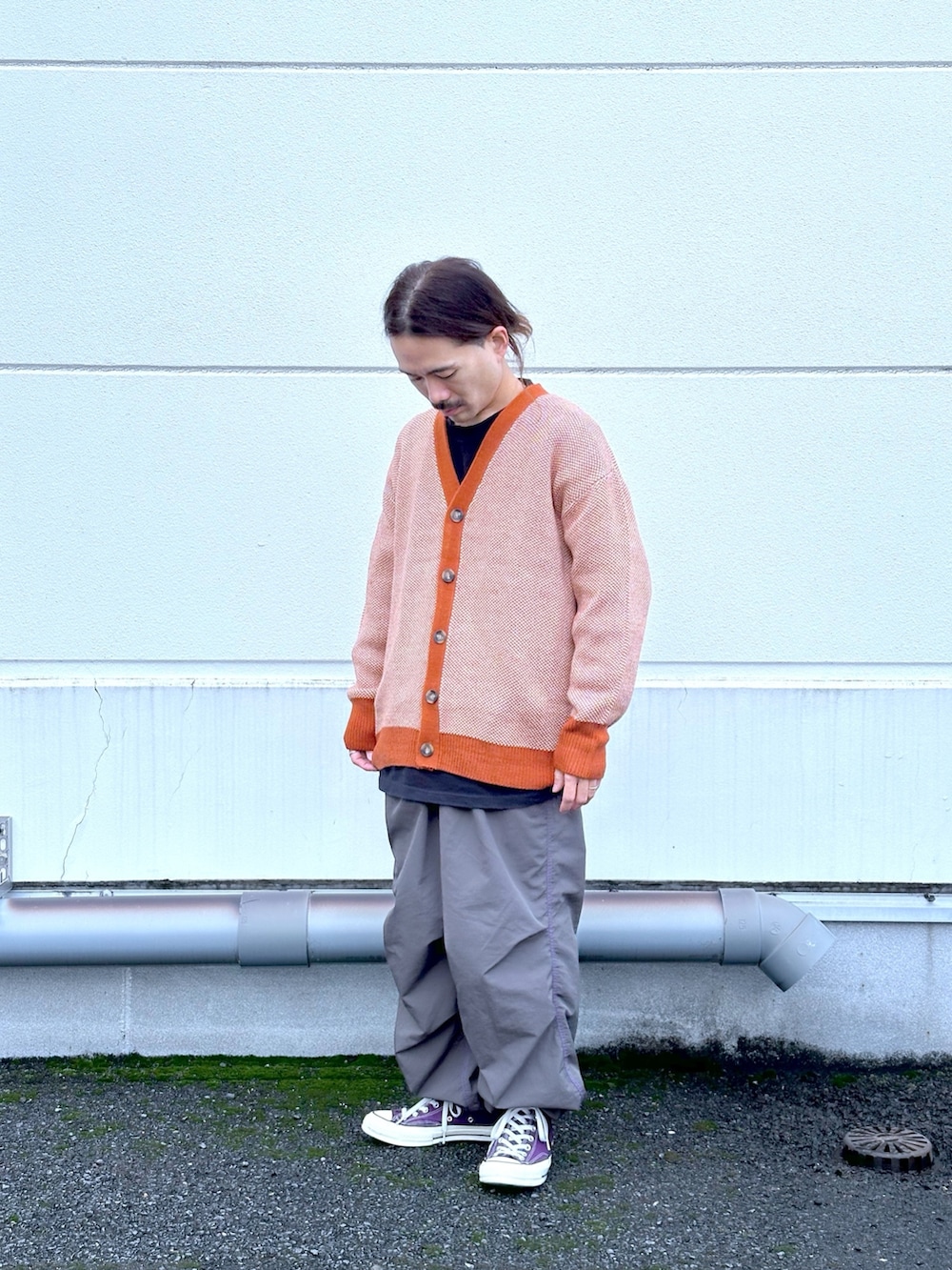 オレンジ系のカーディガン/ボレロ、ブラック系のカーゴパンツを着用したメンズの冬コーディネートの2枚目の写真