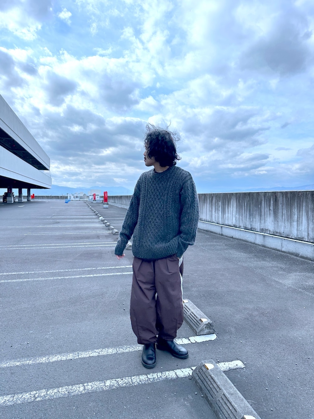 グレー系のニット/セーター、ブラウン系のスウェットパンツを着用したメンズの冬コーディネートの2枚目の写真