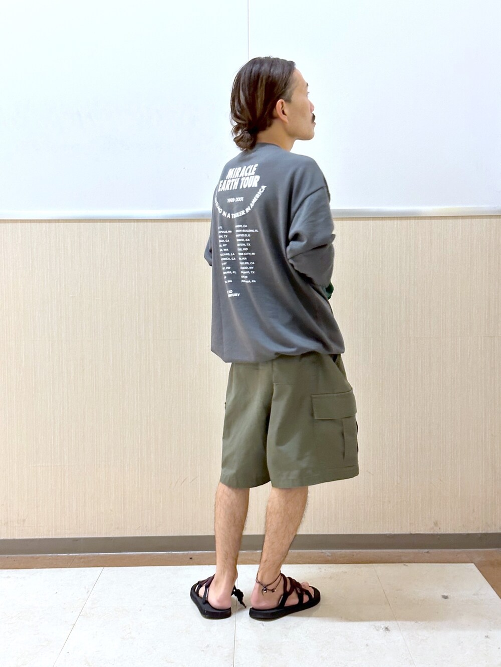 グレー系のTシャツ/カットソー、グリーン系のカーゴパンツ、ブラック系のサンダルを着用したメンズの夏コーディネートの2枚目の写真