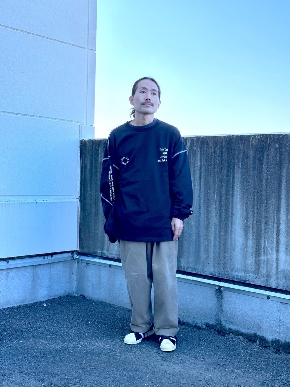 ブラック系のTシャツ/カットソー、グリーン系のチノパンツを着用したメンズの秋コーディネートの2枚目の写真