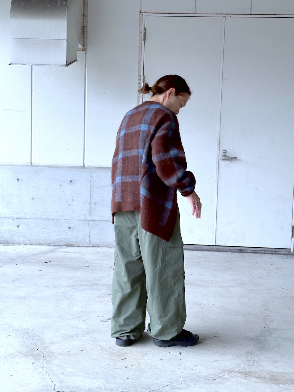 グリーン系のカーゴパンツ、ホワイト系のTシャツ/カットソー、ブラウン系のカーディガン/ボレロを着用したメンズの秋コーディネートの2枚目の写真