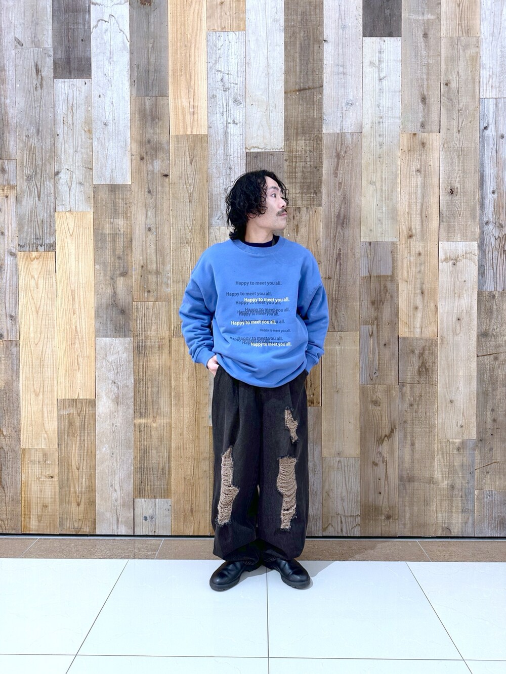 ブルー系のスウェット、ブラック系のデニムパンツを着用したメンズの冬コーディネートの2枚目の写真