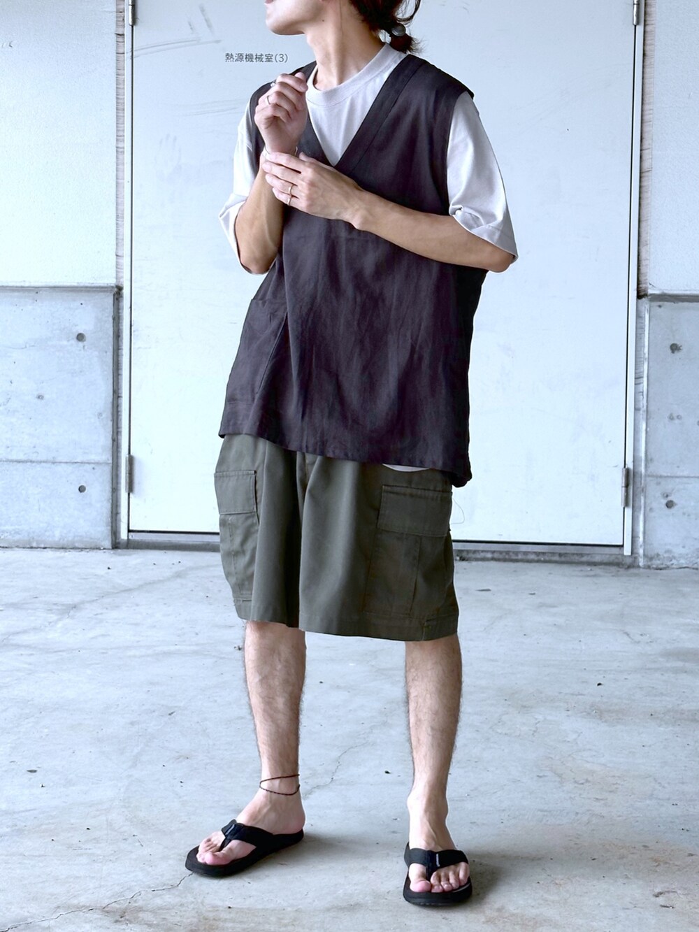 グリーン系のカーゴパンツ、グレー系のベスト、ベージュ系のTシャツ/カットソーを着用したメンズの夏コーディネートの2枚目の写真