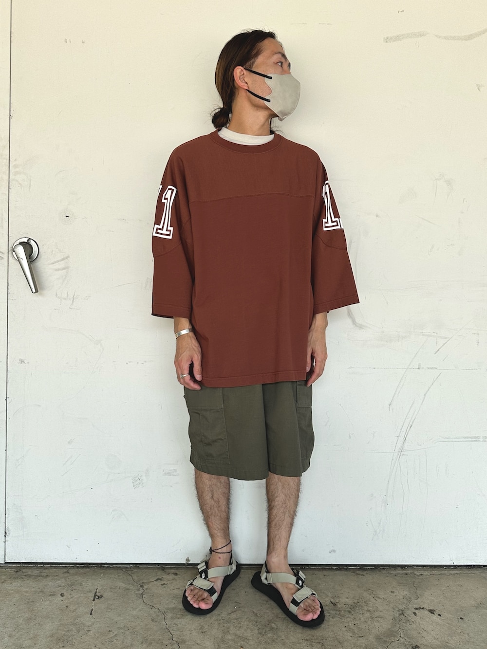 ブラウン系のTシャツ/カットソー、グリーン系のカーゴパンツ、ベージュ系のサンダルを着用したメンズの夏コーディネートの2枚目の写真