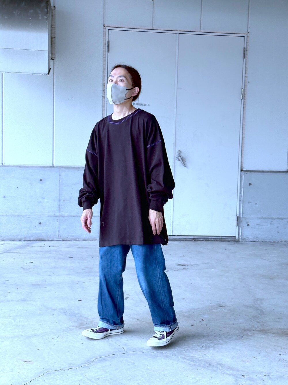 ブラック系のTシャツ/カットソー、ブルー系のデニムパンツを着用したメンズの秋コーディネートの2枚目の写真