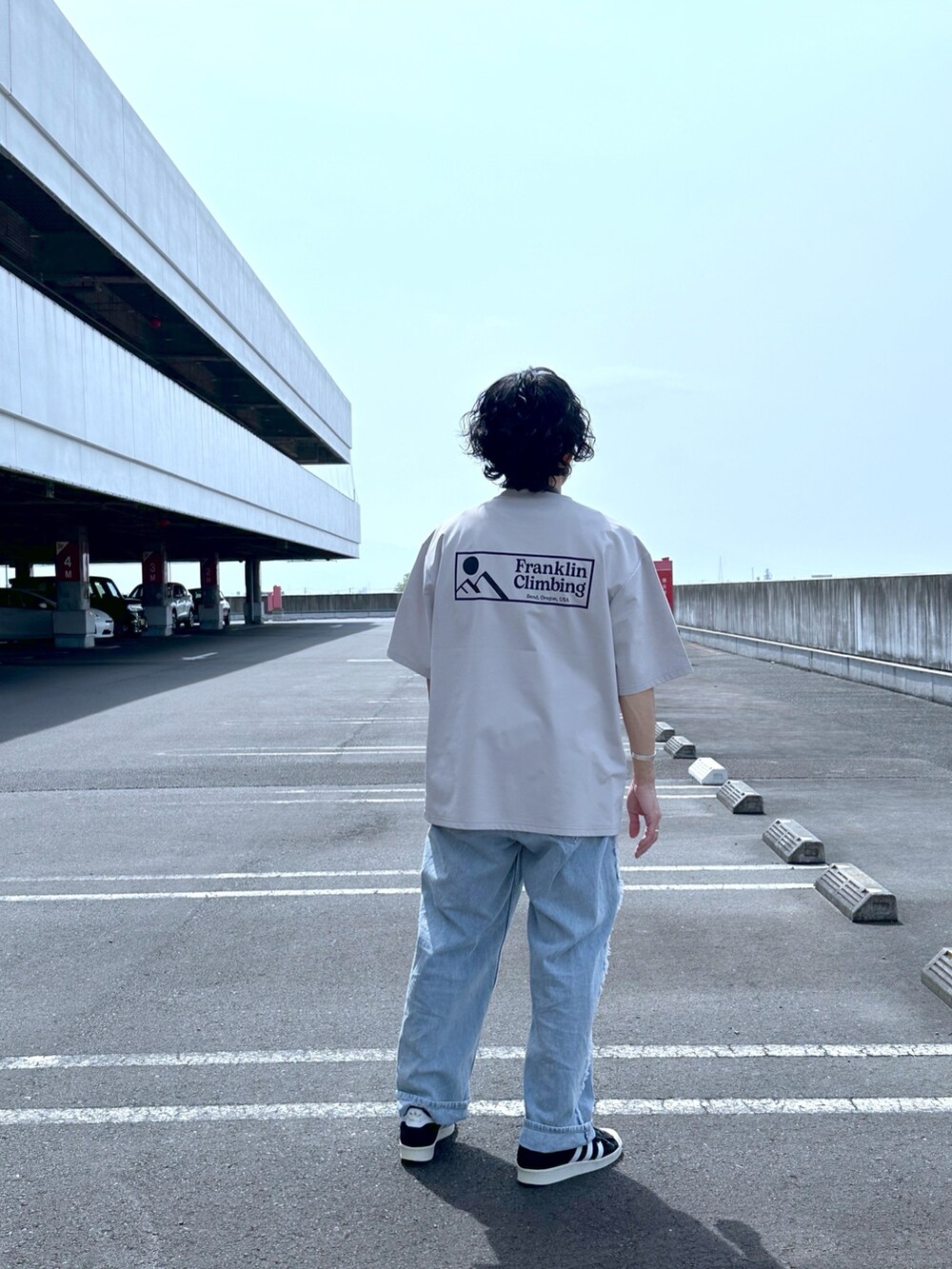 グレー系のTシャツ/カットソー、ブルー系のデニムパンツを着用したメンズの春コーディネートの2枚目の写真