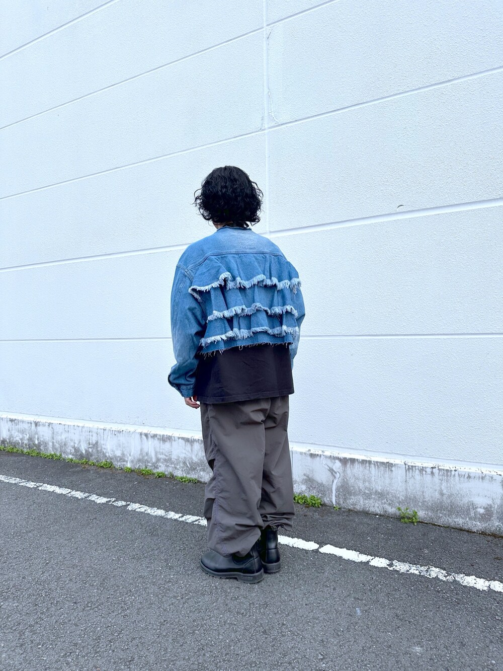 ブルー系のデニムジャケット、ブラック系のカーゴパンツを着用したメンズの春コーディネートの2枚目の写真