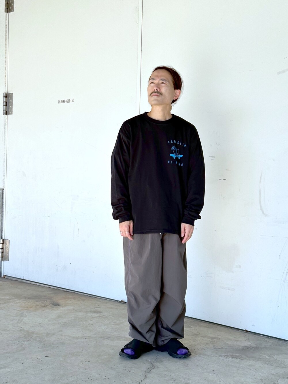 ブラック系のTシャツ/カットソー、ブラック系のカーゴパンツを着用したメンズの秋コーディネートの2枚目の写真