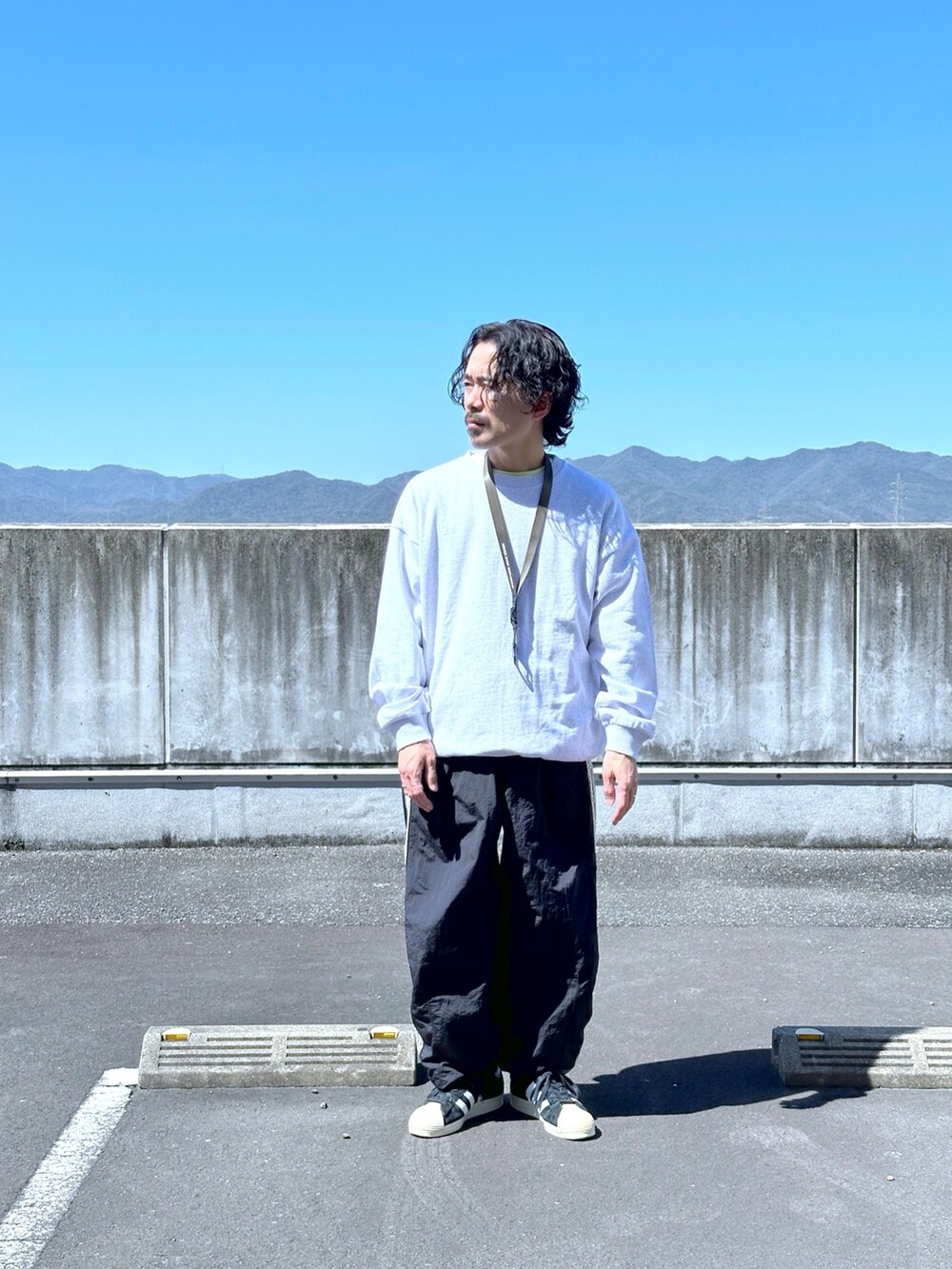 グレー系のスウェット、ブラック系のスウェットパンツを着用したメンズの春コーディネートの2枚目の写真